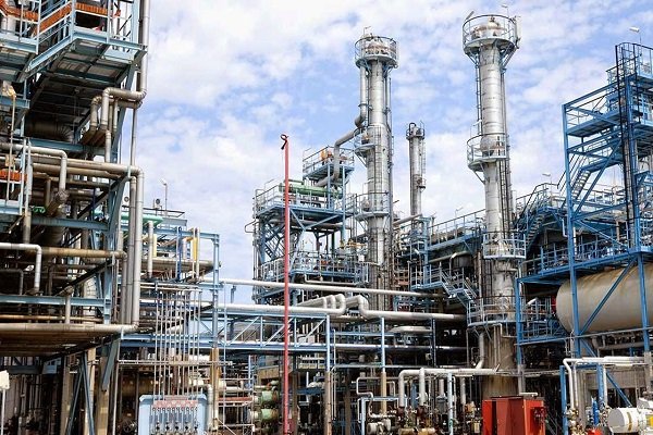 Port-Harcourt-refinery NNPC-operated oil refinery infrastructure with metallic towers, pipelines, and platforms under a blue sky.