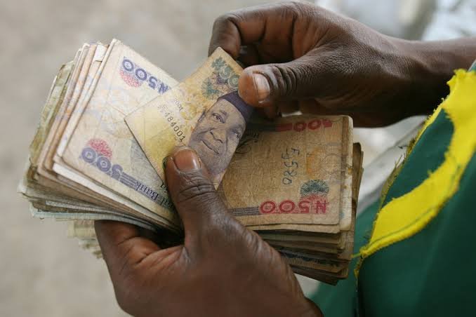 GDP A person counting Nigerian naira notes, representing economic activities and GDP growth