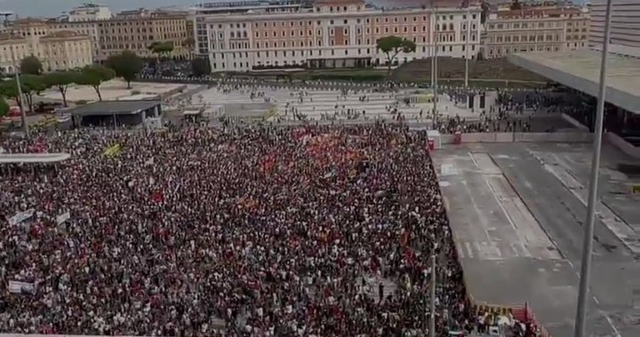 Italy shuts down A massive crowd of protesters in Italy holding banners and flags during a nationwide strike that shut down transport, schools, and offices.