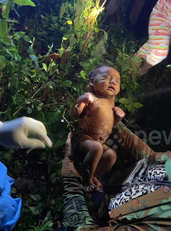 A crying baby discovered inside an abandoned bag in the bush, rescued by passersby.