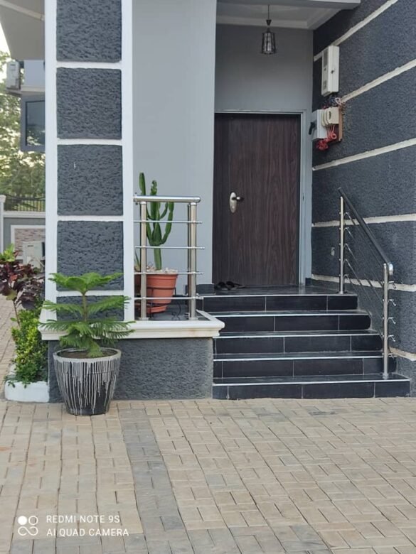 A frightened man carrying his bags while leaving a house after confessing to ritual killings, looking terrified.