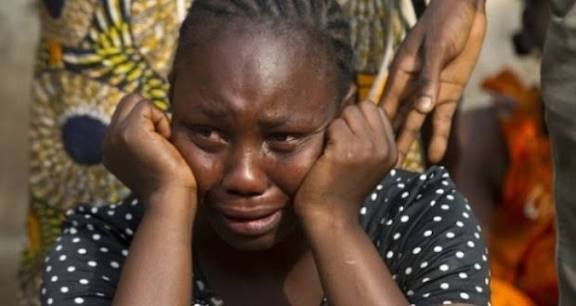 Crying widow A crying widow sits on the floor with her children, pleading for help after her husband’s family seized all his property.