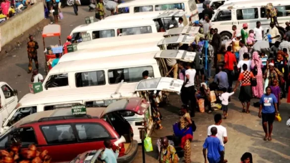 Bus driver physically attacking a lady during a heated argument at a bus park in Rivers State as people watch in shock.